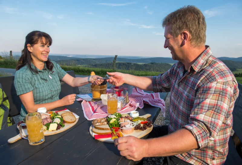 Wanderer bei der Brotzeit an der Graf-Stolberg-Hütte bei Willingen