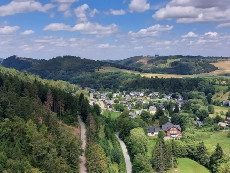 Uitzicht over het dorp in het dal met beboste heuvels erachter – Schattenjacht Linnes Schatz op de Ettelsberg, Willingen