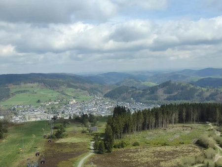 Uitzicht over het dorp diep in het dal met beboste hellingen – Skywalk Willingen vanaf de Muhlenkopfschanze, Willingen