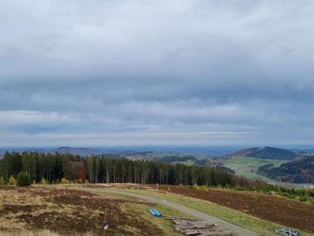 Wijds uitzicht over weiden en beboste heuvels onder een wolkenlucht – Uitzicht op Willingen en het viaduct, Willingen